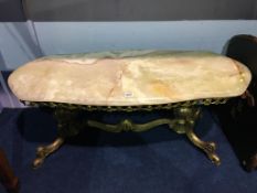 A long onyx coffee table, with ornate and heavy brass base