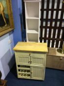 A narrow white bathroom cabinet and a cream kitchen cabinet