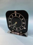 An Art Deco clock with square black glass dial, on chrome stand, stamped 'Made In England', 18.5cm