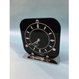 An Art Deco clock with square black glass dial, on chrome stand, stamped 'Made In England', 18.5cm