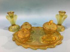 An amber coloured seven piece glass dressing table set