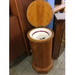 A Victorian cylindrical wash stand, the rising top opens to reveal a washbowl below a single door,