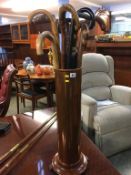 A tall cylindrical copper stick stand and various sticks, 69cm height