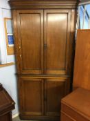 An oak standing corner cabinet, with four plain panelled doors