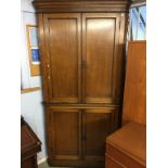 An oak standing corner cabinet, with four plain panelled doors