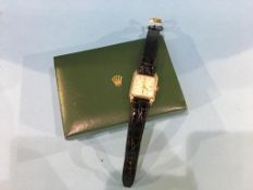 A 9ct gold Rolex watch, with rectangular dial, second hand dial, batons, leather strap, with leather