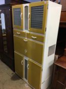 A fantastic 1950's kitchen cabinet, with drop down enamel front opening to reveal compartments for