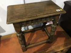 An oak stool with acanthus carved legs