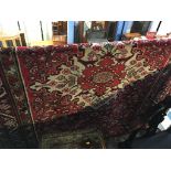 A Hamadan rug, the large floral medallion in pinks and ivory and having a triple guard stripe. 300cm