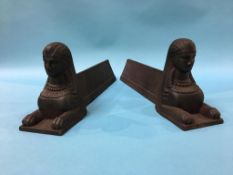 A pair of cast iron Egyptian style fire dogs