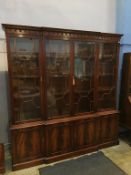 A reproduction mahogany breakfast four door bookcase, with cupboards below, 202cm wide, 214cm height