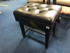 A good quality black leather rising piano stool