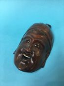 An Oriental carved wood face mask