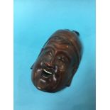 An Oriental carved wood face mask