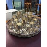 A large circular silver plated tray supported on claw feet and a selection of goblets
