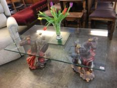 A rectangular glass top coffee table and a pair of figural supports, 119 x 70cm