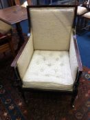 An Edwardian mahogany armchair with button seat, supported on turned legs and brass castors