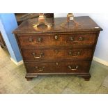 A small Georgian oak chest of drawers, with three long graduating drawers, supported on bracket