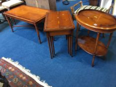 A yew wood coffee table, nest of tables and a two tier oval occasional table