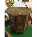 A heavily carved octagonal folding occasional table