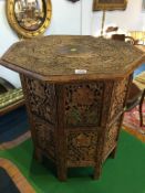 A heavily carved octagonal folding occasional table
