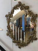 A metal floral oval mirror, 64 x 45cm