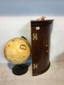 A terrestrial globe and a small corner cabinet