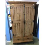 A pine two door hall cabinet / coat stand, with two drawers, 104cm wide, 37cm deep