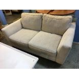 An oatmeal two seater sofa