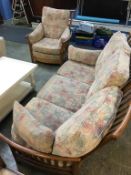 An Ercol three seater sofa with armchair and footstool