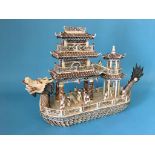 An Oriental figure group of a dragon boat