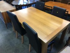 A modern oak dining table and four chairs
