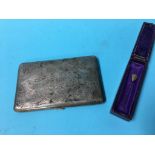 A cigarette case marked 'silver' and a coloured pin