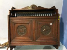 A carved oak hanging two door cabinet