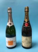 A bottle of Veuve Clicquot champagne and a bottle of Moet champagne