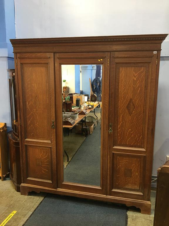 An Edwardian oak triple door wardrobe