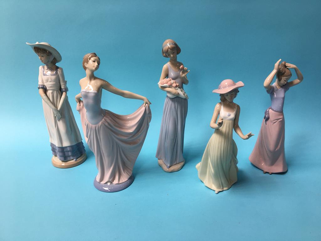 A Lladro figure of a lady holding her dress aloft and four Nao figures (5)