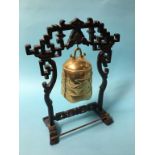 An Oriental brass hanging bell, with carved wood stand