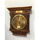 A wall mounted oak and barley twist barometer