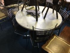 A white circular kitchen table with four metalwork chairs, circa 1970s