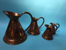 Four graduated copper jugs