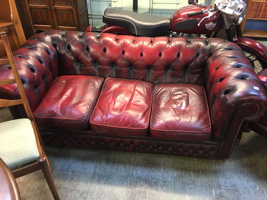 A leather oxblood three seater Chesterfield sofa