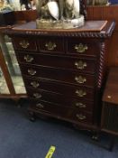 A reproduction mahogany straight front chest with three short and five long drawers, with mirror