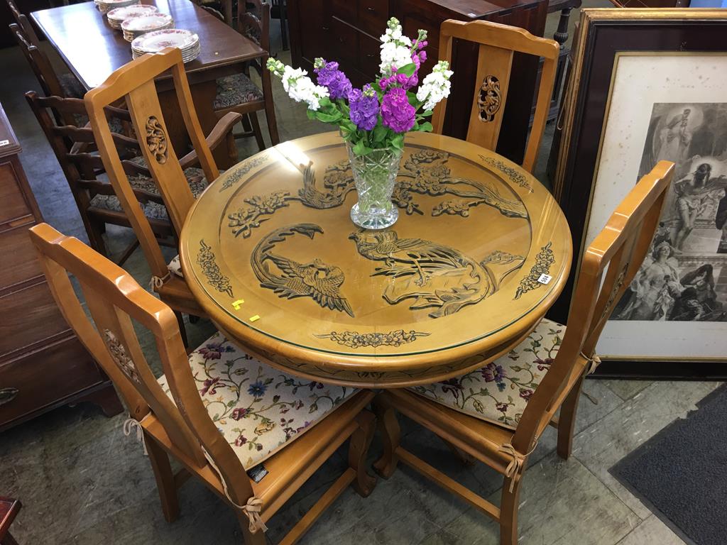 An Oriental design carved circular table and four chairs
