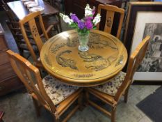 An Oriental design carved circular table and four chairs