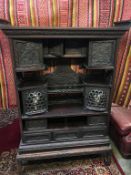 An early 20th century heavily carved Japanese side cabinet, the top section with four carved and