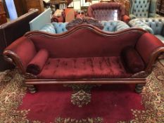 A Victorian mahogany scroll end settee, with scrolled and carved back, supported on turned