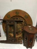 A carved octagonal table, a large decorative circular plaque and a folding Indian table