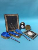 A silver enamelled dressing table set and a selection of silver photograph frames