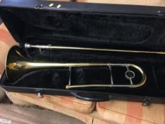 A cased Trombone, with Trombone Faber Music books